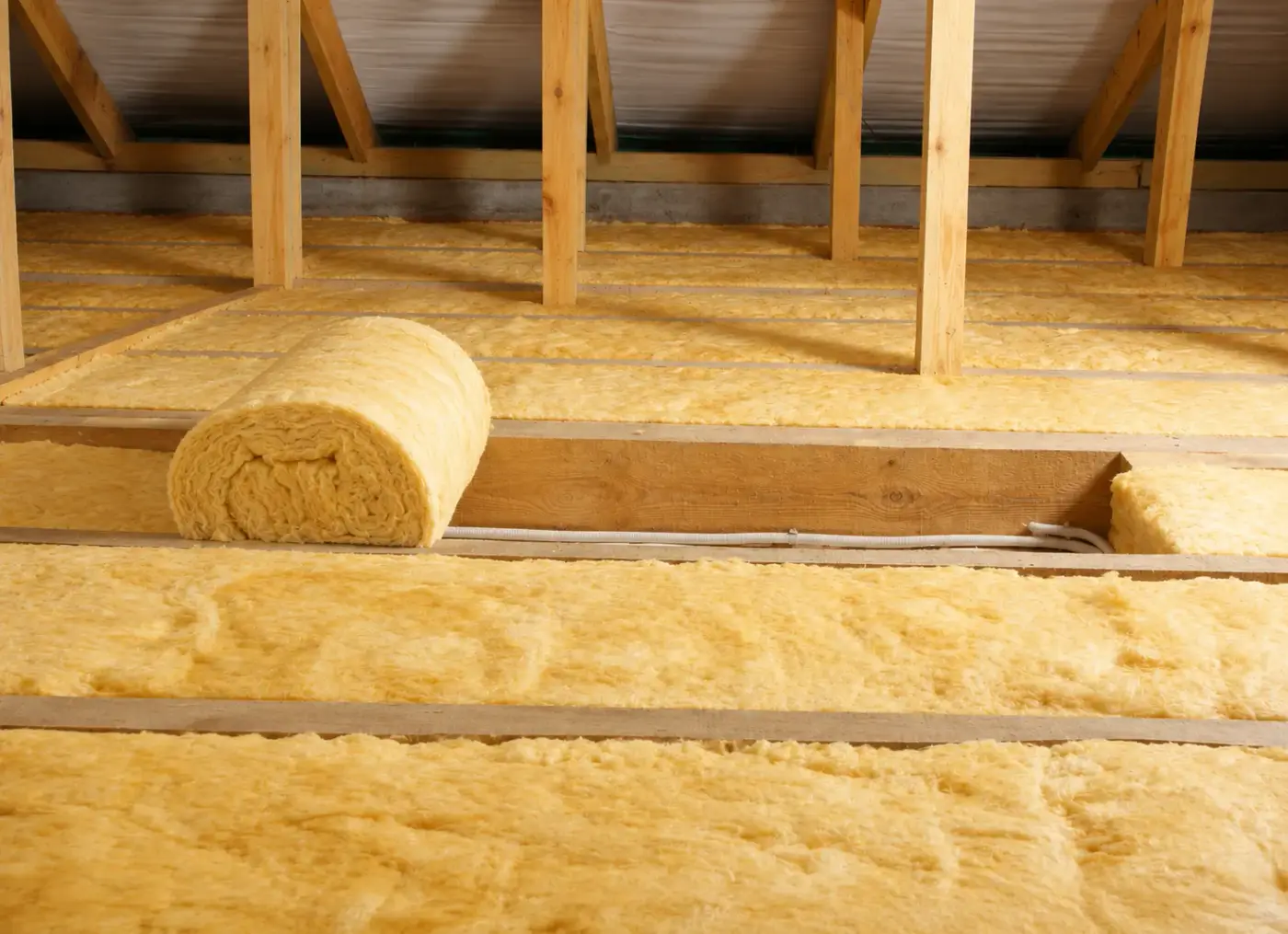 Loft insulation rolls installed between timber joists